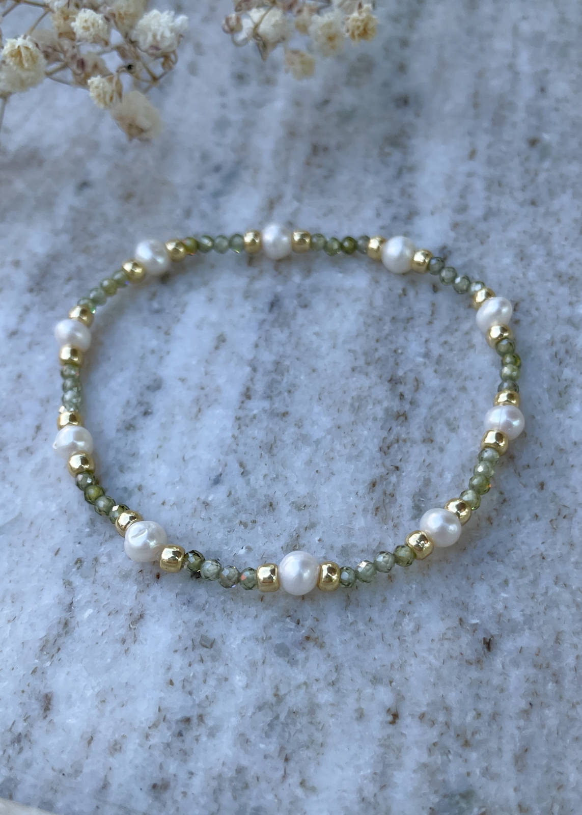 Bracelet on an elastic band with khaki cubic zirconia and natural pearl